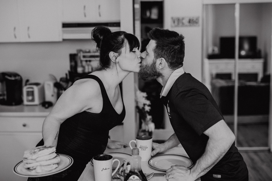 kissing in the kitchen with maternity photos