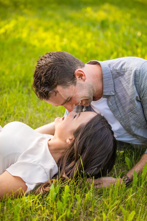he is kissing her on the green grass of their ranch