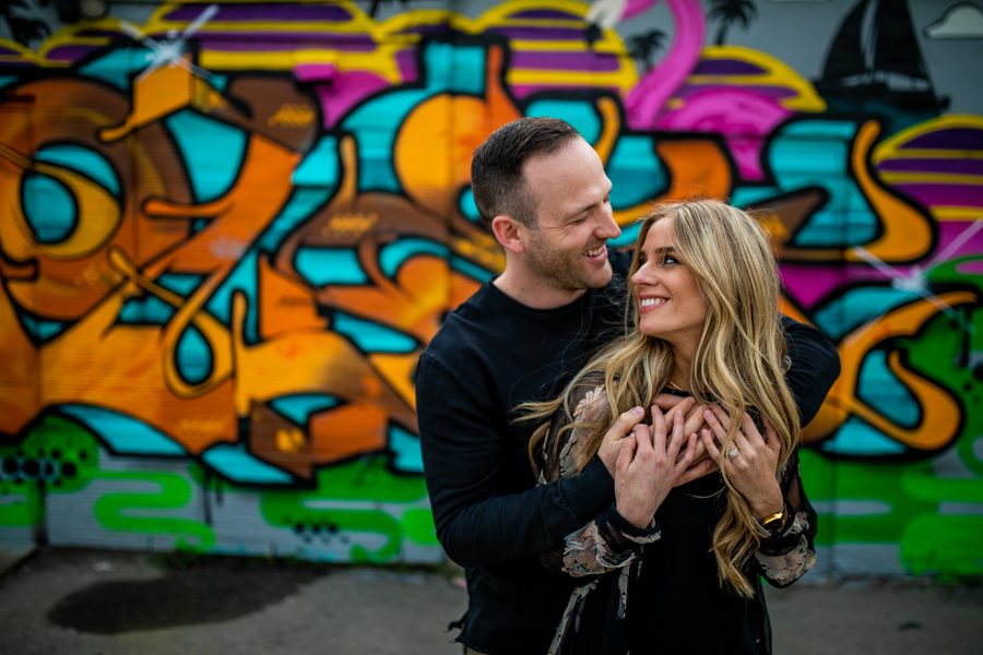 couple getting a picture taken infant of graffiti