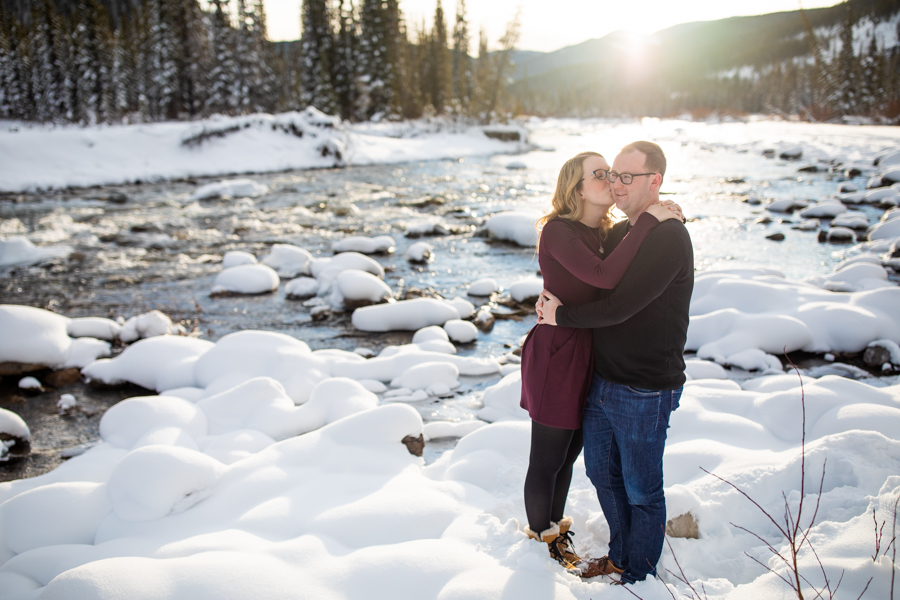 Couple having their picture taken in the snow with sun shining