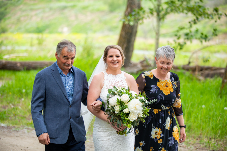 bride walking with parents to her fish creek park elopement