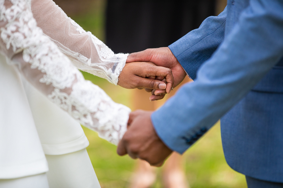 couple hiding hands ready to elope in Lindsay Park