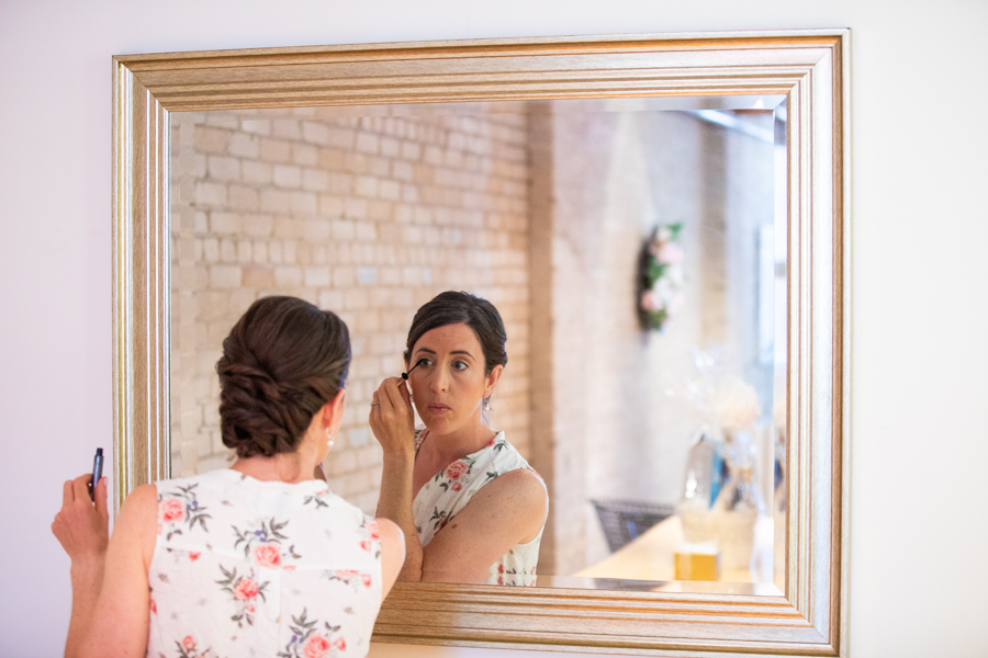 Bride putting on make up in edmonton elopement