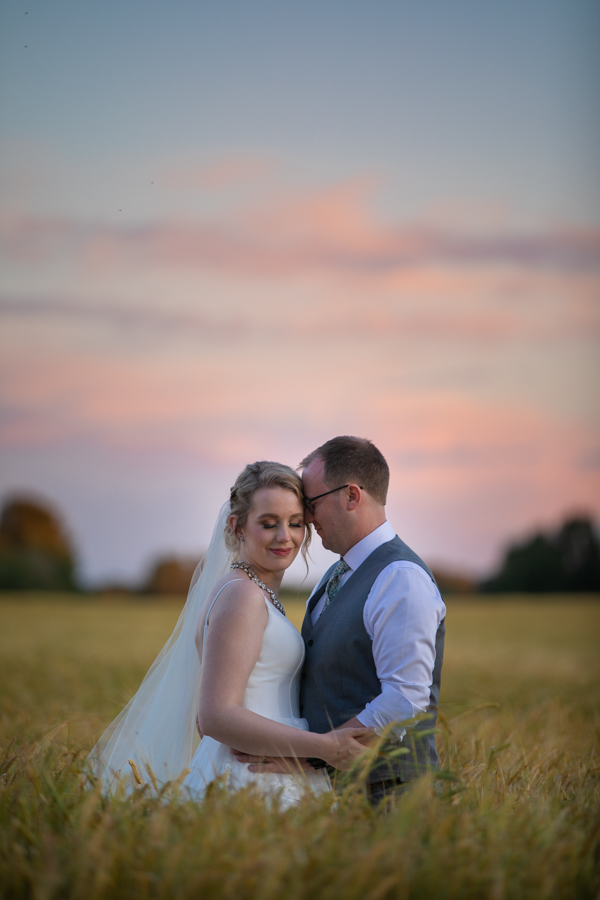 amazing sunset in a wheat field with couple at pine and pond
