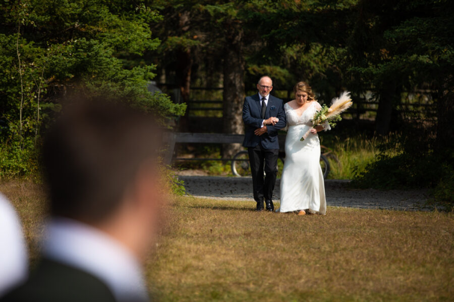 bride and dad walking down the aisle at Canmore Ranch wedding venue