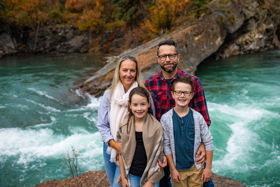 Amazing Family Photo Locations family standing next to a waterfall