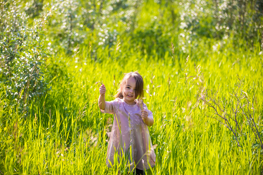 little girl running through long grass in fish creek park