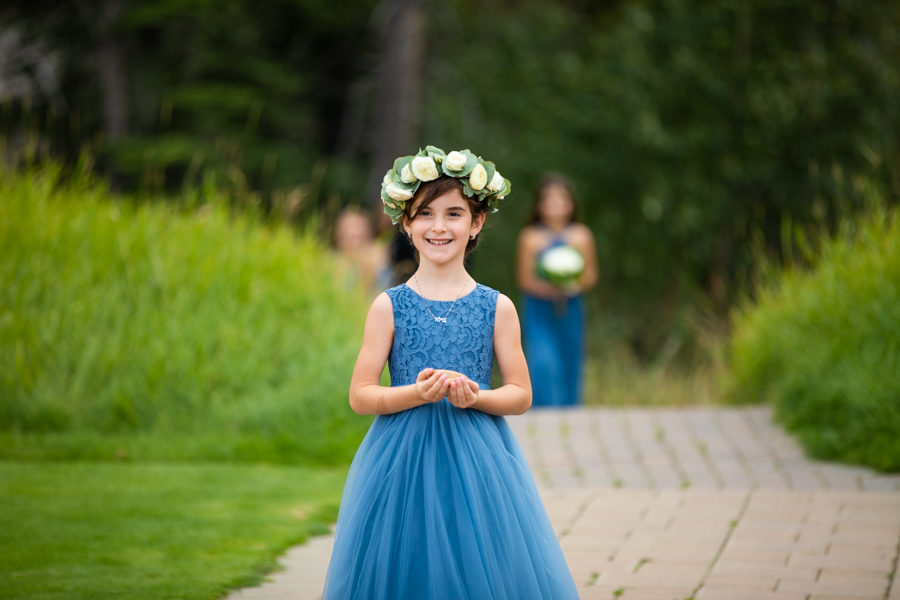 Flower girl coming down the aisle at silvertip canmore elopement