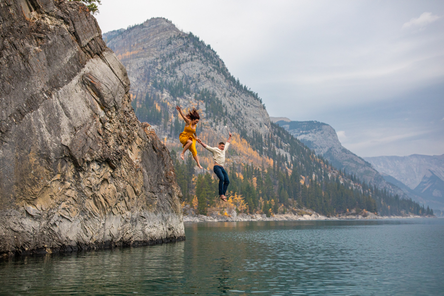 Lake minnewanka sunrise engagement, couple in the water at lake minnewanka, lake minnewanka cliff jumping couple