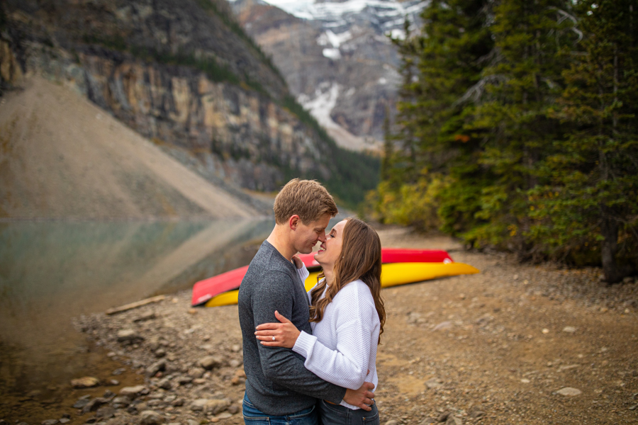 Lake Moraine Engagement Photos with Canoes in the backdrop