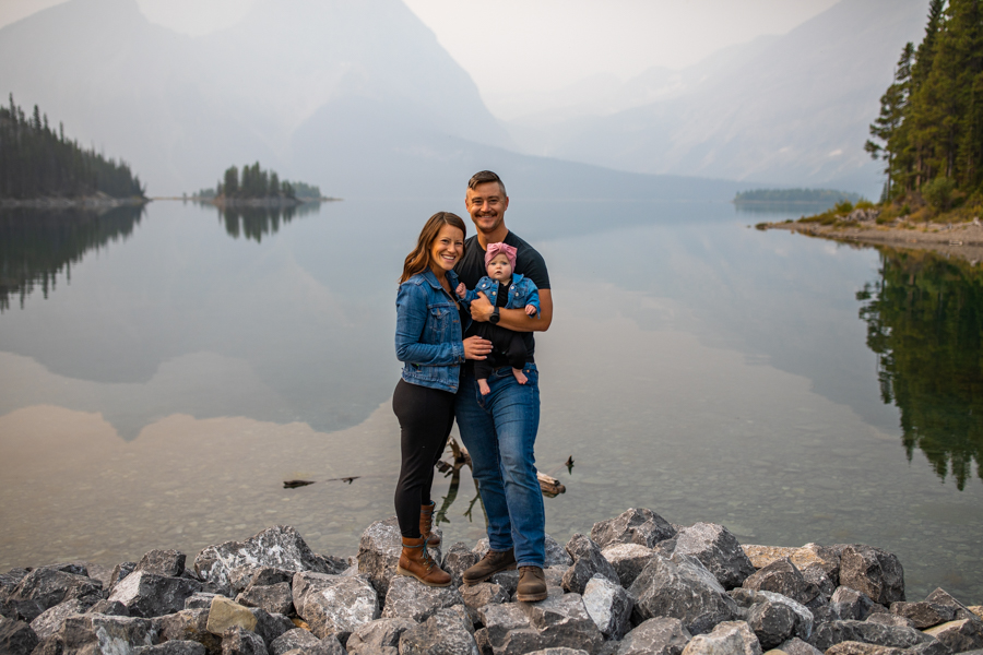 family of three infant of a lake for portrait