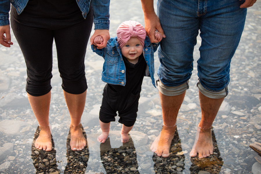 family of three standing in the water for potraits